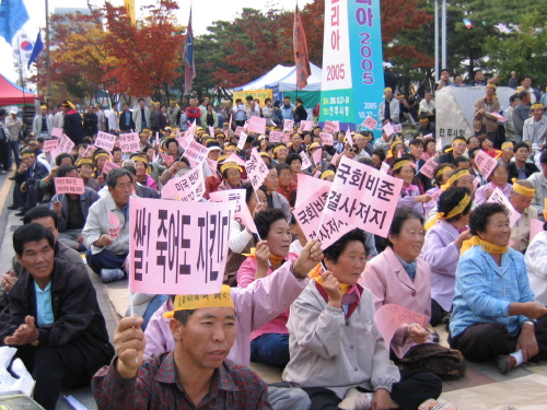 '쌀 죽어도 지킨다', '국회 비준 결사저지' 등의 문구가 새겨진 깃발을 흔들고 있는 농민들 